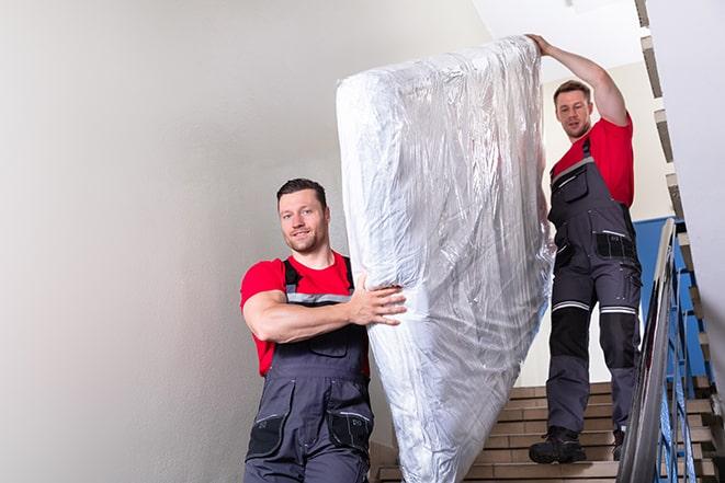 team of workers handling a box spring for disposal in Fremont